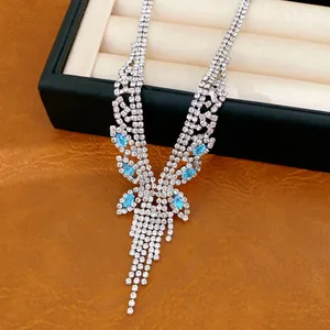 Détail d'un collier de luxe à pompons en zircon argenté avec des pierres bleu clair