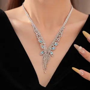 Gros plan détaillé d'un collier de luxe argenté à pompons en zircon et pierres précieuses bleu clair