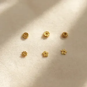 Gros plan montrant six styles de perles intercalaires en acier inoxydable plaqué or 18 carats