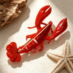 Detailed macro view of the red lobster brooch on a beach-themed background