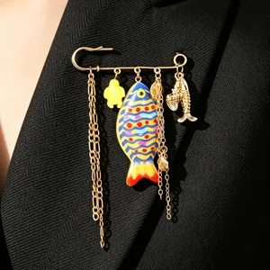 Close-up detail of a gold-toned ocean theme brooch featuring a colorful fish charm on a blazer.