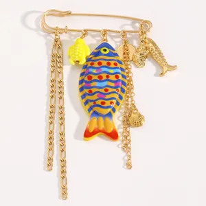 Dettaglio di una spilla colorata con ciondoli a forma di pesce e tartaruga marina