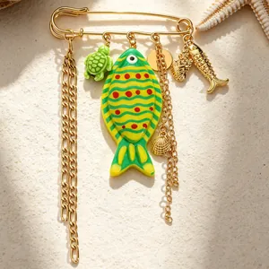 Detailed close-up of an ocean-themed safety pin brooch with colorful fish and turtle charms
