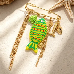 Close-up detail of a marine themed brooch featuring colorful fish and sea turtle charms.