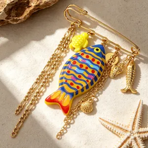 Detailed view of ocean-themed brooch featuring colorful fish and golden sea charms