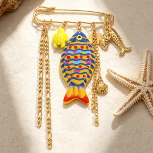 Close-up detail of beach-themed alloy brooch with colorful fish and sea turtle charms