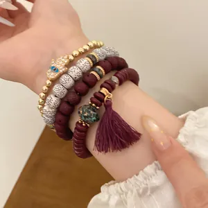 Close-up of bohemian beaded bracelet set with tassel and gold Hamsa charm on wrist
