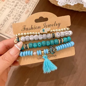 Close-up of Bohemian 4-piece beaded bracelet set with Hamsa hand and blue tassel