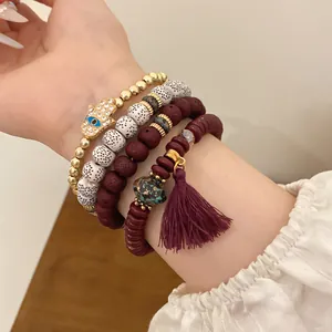 Detailed view of ethnic style beaded bracelet set with Hamsa hand and purple tassel