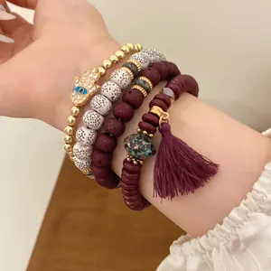 Detailed view of ethnic style bracelet set with Hamsa hand charm and purple tassel detail.