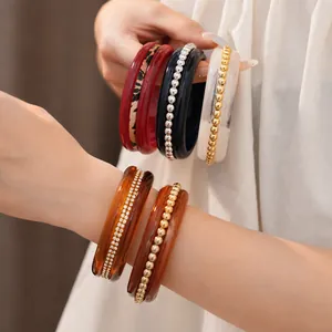 Elegant set of diverse resin bangles featuring leopard print and gold bead details