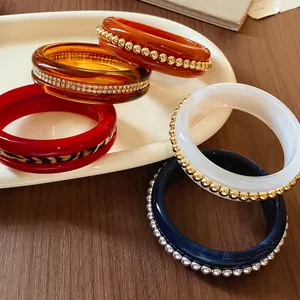 Variety of stylish resin bangles with rhinestone, bead, and leopard print details.