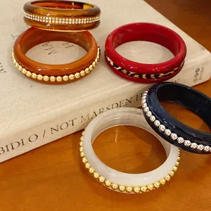 Macro view of vintage resin bangles featuring rhinestone, leopard print and metallic bead details