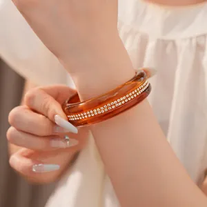 Detailed macro shot of an amber resin bangle with double rows of sparkling inlaid rhinestones