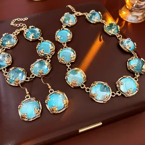 Parure de bijoux élégante avec gemmes bleu clair et cadres floraux dorés pour femme