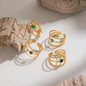 Dettaglio di anelli multistrato in acciaio inossidabile retrò con pietre naturali e oro 18K