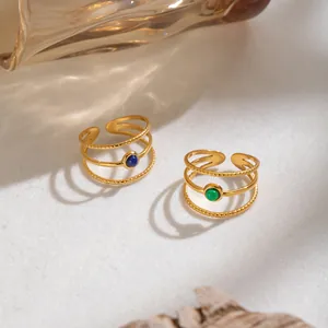 Primo piano di anelli vintage in acciaio inossidabile placcati oro 18K con pietra naturale.