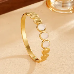 Detailed close-up view of a Bohemian gold titanium steel bangle with white stone inserts.