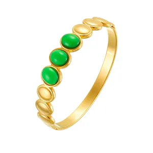 Detailed view of bohemian gold-plated stainless steel bangle with green oval stones