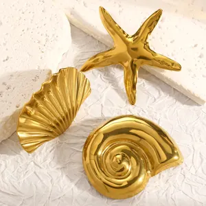Set de tres broches dorados con formas de estrella de mar, concha y caracola marina