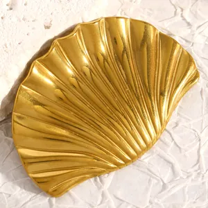 Primer plano de un broche en forma de concha de acero inoxidable dorado pulido