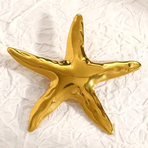Primer plano detallado de un elegante broche de estrella de mar de acero inoxidable dorado