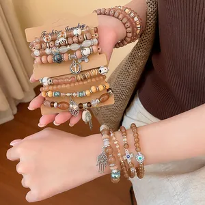 Detailed view of bohemian style beaded bracelet set featuring hamsa and evil eye charms