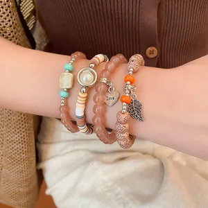 Close-up of bohemian multi-layer bead bracelet set with heart and leaf charms