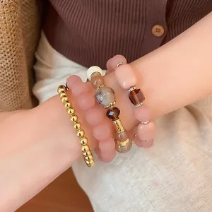 Close-up of bohemian beaded bracelet set featuring pink acrylic and gold beads