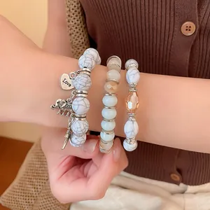Close-up of Bohemian style marble bead bracelets featuring elephant and Love heart charms