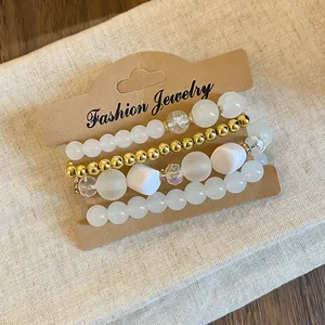Detailed view of Bohemian bead bracelet set with gold and white acrylic beads.