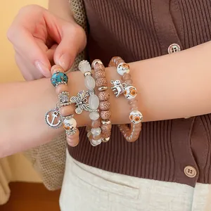 Detail view of bohemian beaded bracelet set with elephant and butterfly charms