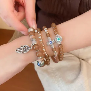 Detail view of bohemian beaded bracelet set featuring evil eye and hamsa hand charms on wrist