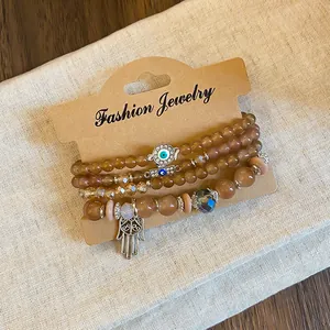 Detail view of Bohemian beaded bracelet set with Evil Eye and Hamsa hand charms.