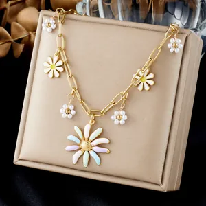 Detail view of gold thick link necklace with colorful daisy and pearl charms