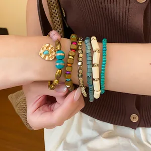 Close-up of bohemian layered beaded bracelet set with heart charm and turquoise beads