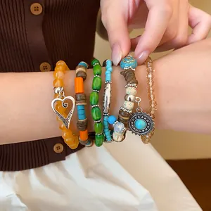 Close-up of bohemian multi-layer beaded bracelet set with heart and sun charms