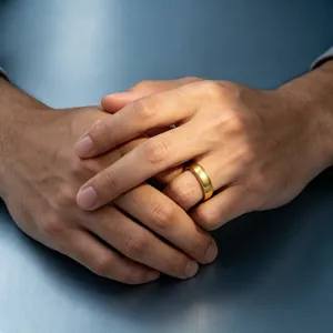 Close-up detail of a classic brushed gold titanium steel band ring worn on a hand