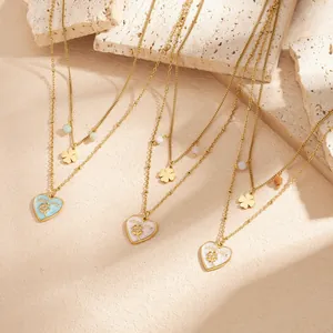 Macro view of double-layer stainless steel gold necklaces with heart and flower charms