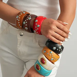 Detail of vintage chunky resin and wood bangles with flower studs and large gems.