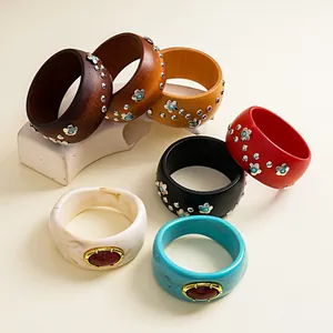 Macro view of vintage wooden and resin chunky bangles with flower rivets and gem details