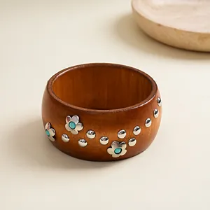 Detailed close-up of a vintage-style wooden bangle with silver floral and rivet accents