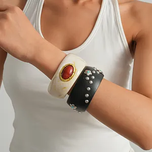 Close-up of vintage resin marbled and black wood flower rivet wide bangle set on wrist