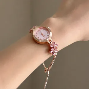 Elegant rose gold flower watch bracelet with pink crystals worn on a female wrist