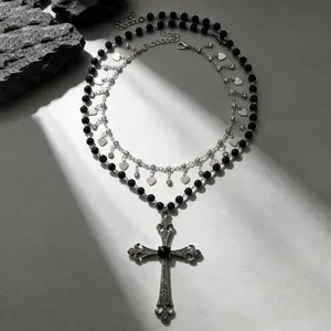 Détail d'un collier gothique vintage avec perles noires et grand pendentif croix