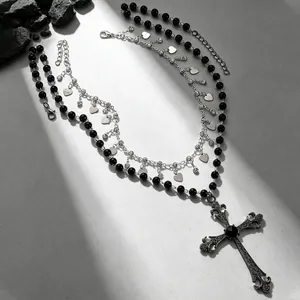 Vue détaillée d'un collier gothique avec croix, perles noires et pendentifs en forme de cœur