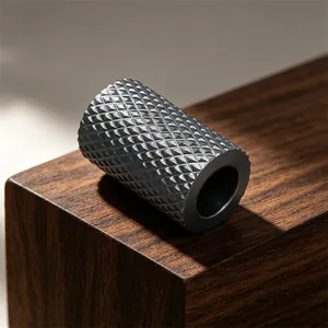 Macro shot of a black cylindrical bead with a diamond knurled texture for jewelry.