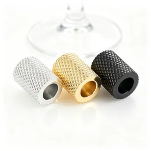 Close-up of diamond textured cylindrical spacer beads in silver, gold, and black