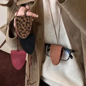 Collier pochette à lunettes en cuir triangulaire avec motif léopard et divers coloris.