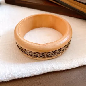 Detailansicht eines handgefertigten Holzarmreifs mit geflochtener Vintage-Textur